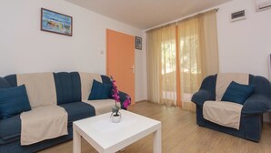 Ein Wohnzimmer mit zwei Sofas, einem Couchtisch und einem Gemälde an der Wand.