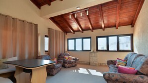A spacious living area with a high ceiling, built-in wooden beams, and large windows providing natural light. - Apartment 38 (Fazana)