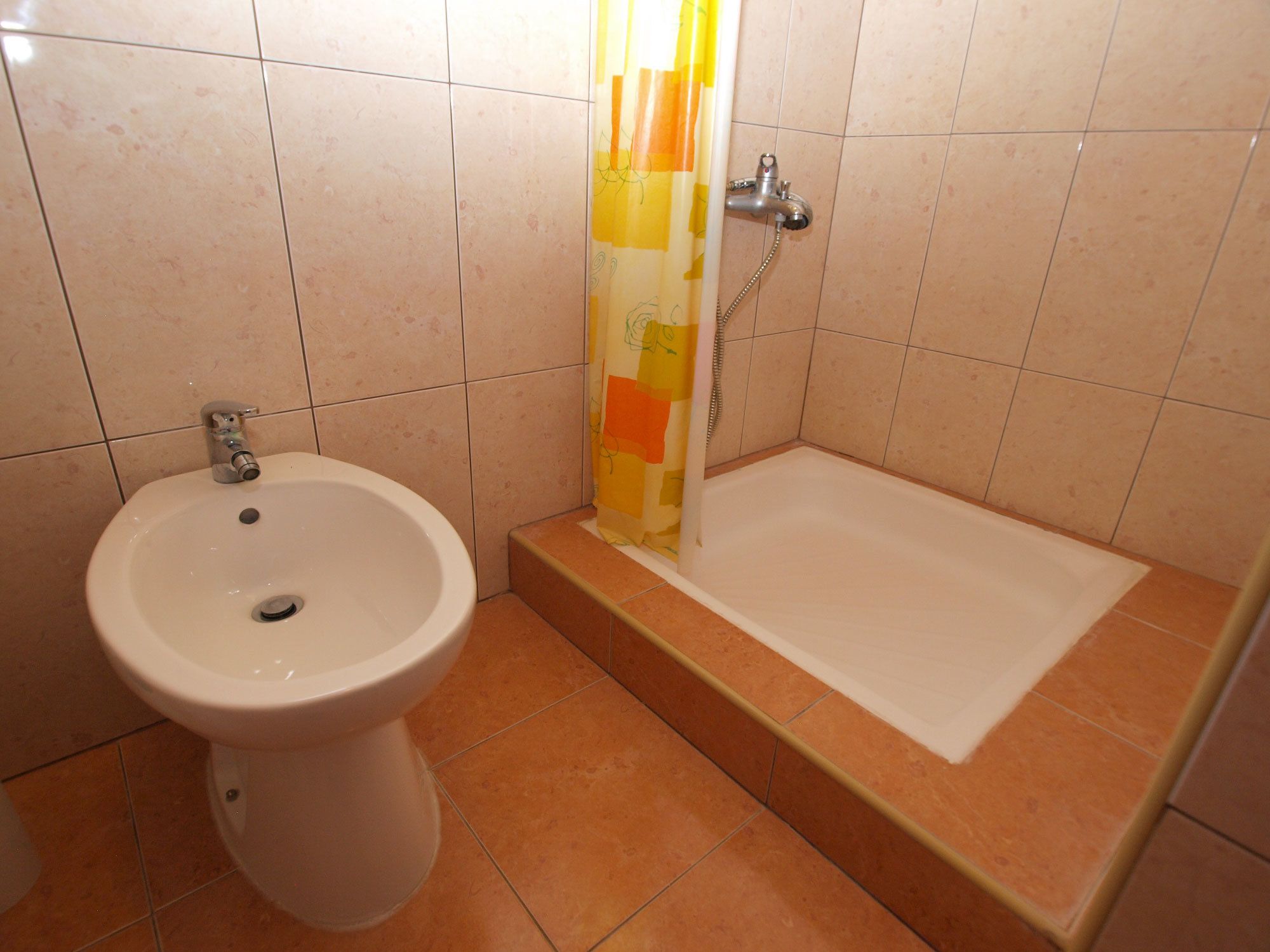 Un baño con lavamanos blanco, un bidé y una bañera.