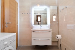 A compact bathroom with a white sink, a mirror, and a toilet. - Apartment 43 (Pula)