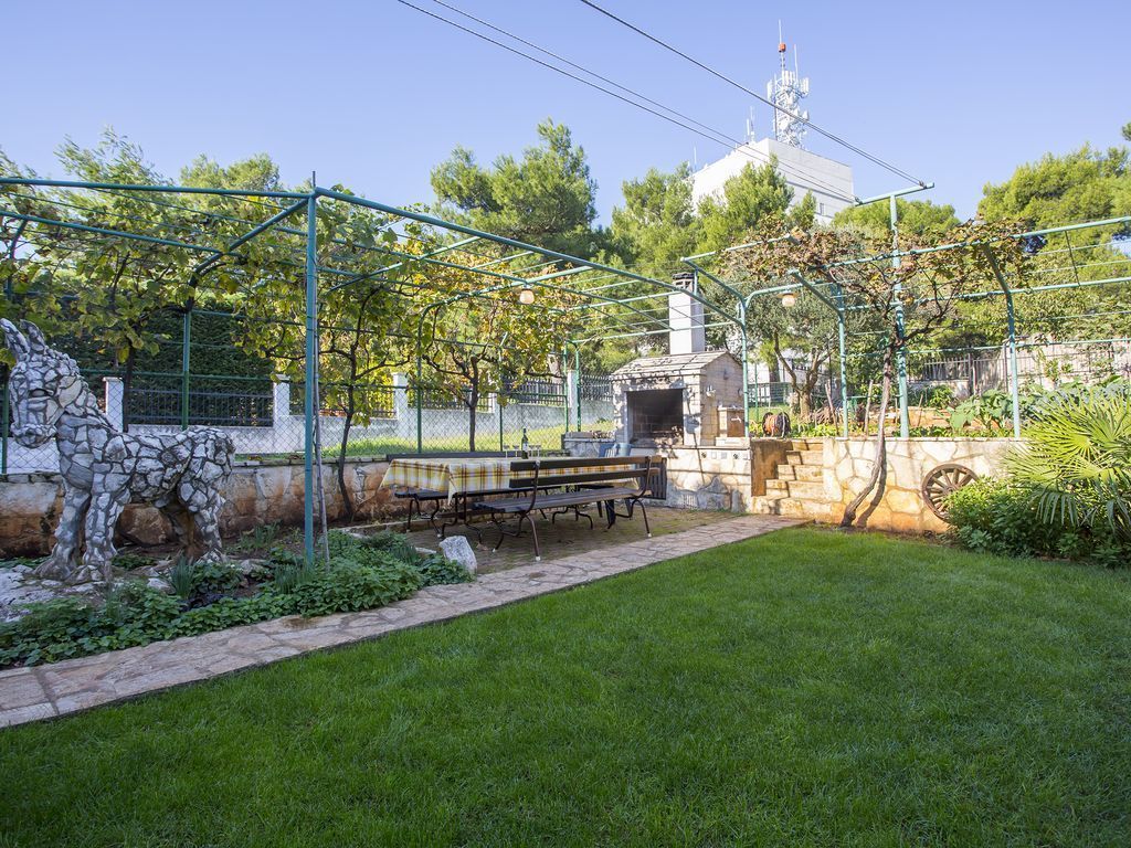 A park with a stone sculpture, a picnic table, and a stone wall.