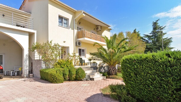 A two-story building with a balcony, a satellite dish, and a paved driveway leading to the entrance. - Apartment 72 (Pula)