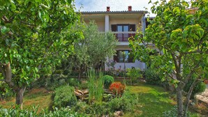 Un immeuble de deux étages avec un jardin à l’avant.