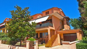 A two-story building with a balcony, a staircase, and a gated entrance. - Apartment 250 (Fazana)
