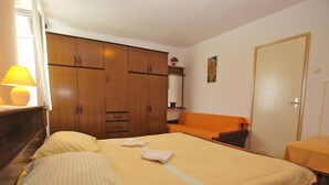 Une chambre à coucher avec un lit, un canapé, une armoire et une table.