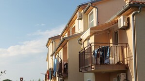 A multi-story residential building with balconies, air conditioning units, and a satellite dish. - Apartment 258 (Pula)