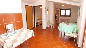 A room with a dining table, chairs, a coffee machine, and a TV. - Apartment 297 (Porec)