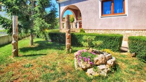 A house with a stone facade, a wooden door, and a window with blue curtains. - Apartment 316 (Fazana)