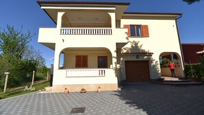 A two-story house with a balcony, a garage, and a paved driveway. - Apartment 344 (Fazana)