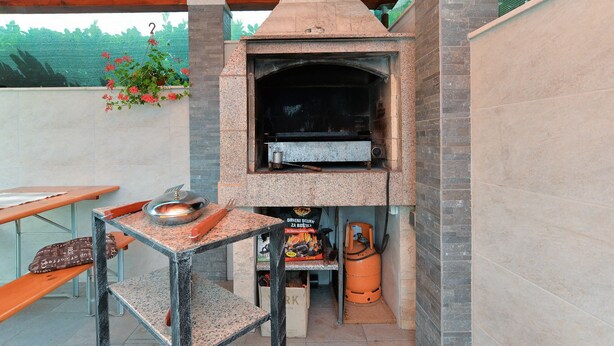 An outdoor brick oven with a table and chairs nearby. - Apartment 344 (Fazana)