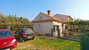 Ein Wohnhaus mit Garten und zwei Autos auf der Auffahrt.