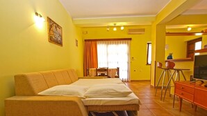 A hotel room with a sofa bed, a television, a small table, and a chair. - Apartment 389 (Pula)