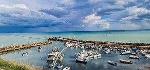 A marina with boats docked, a pier, and a rocky shoreline. - B&B Oikos Selinunte (Castelvetrano)