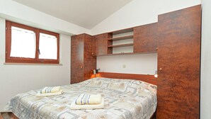 Une chambre à coucher avec un lit, une fenêtre et des meubles en bois.