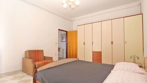 A bedroom with a bed, a chair, a wardrobe, and a chandelier. - Apartment 539 (Medulin)