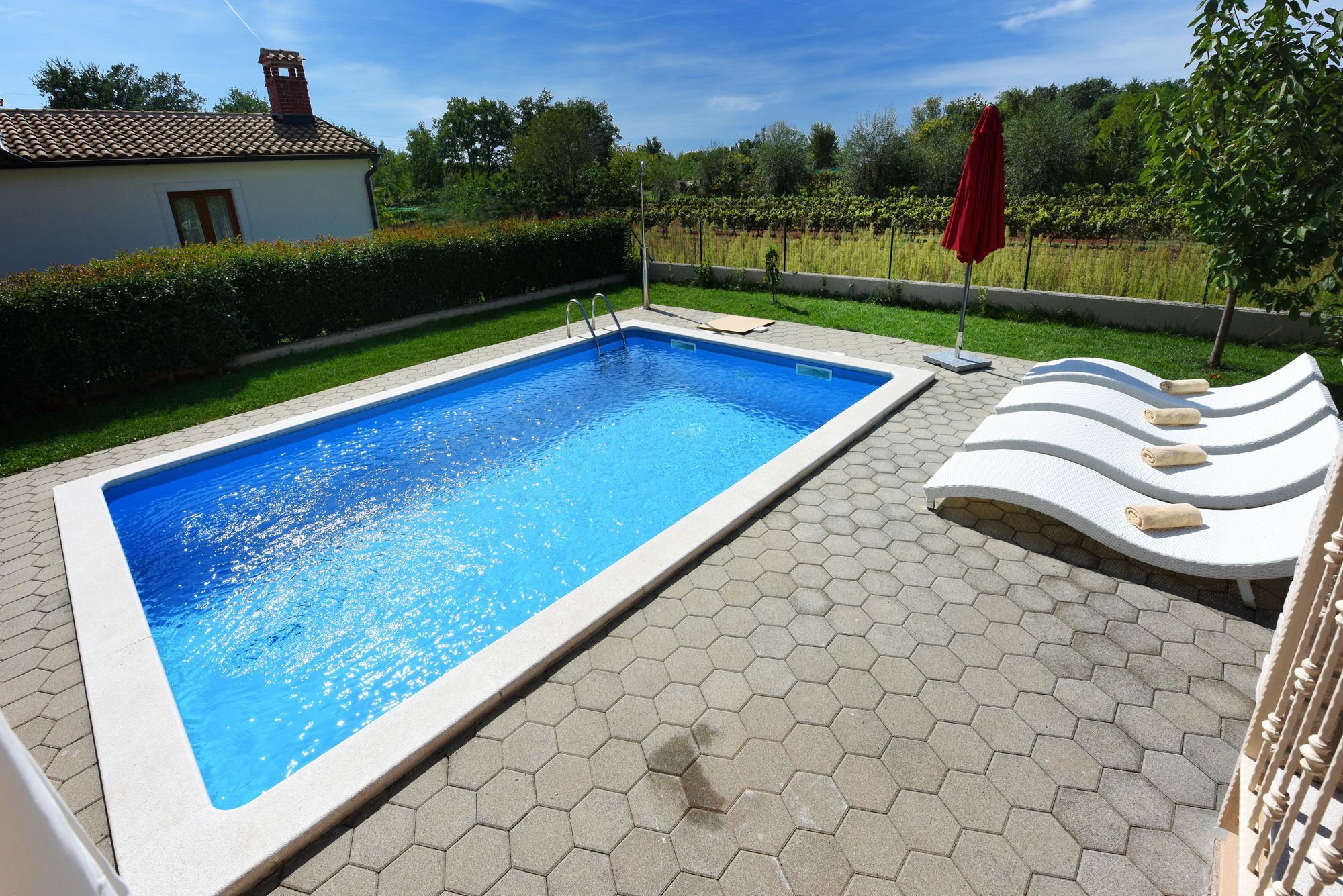 A rectangular swimming pool with a tiled edge, surrounded by hexagonal tiles.