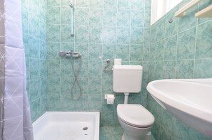 A bathroom with a shower, toilet, and sink. - Apartment 623 (Fazana)
