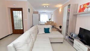 A modern living room with a white sofa, a TV, and a bookshelf. - Apartment 640 (Pula)