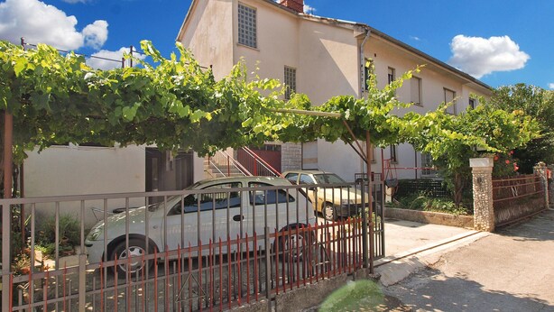 A residential building with a car parked in front. - Apartment 695 (Pula)