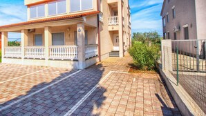 A two-story building with a covered porch and a gated entrance. - Apartment 696 (Fazana)