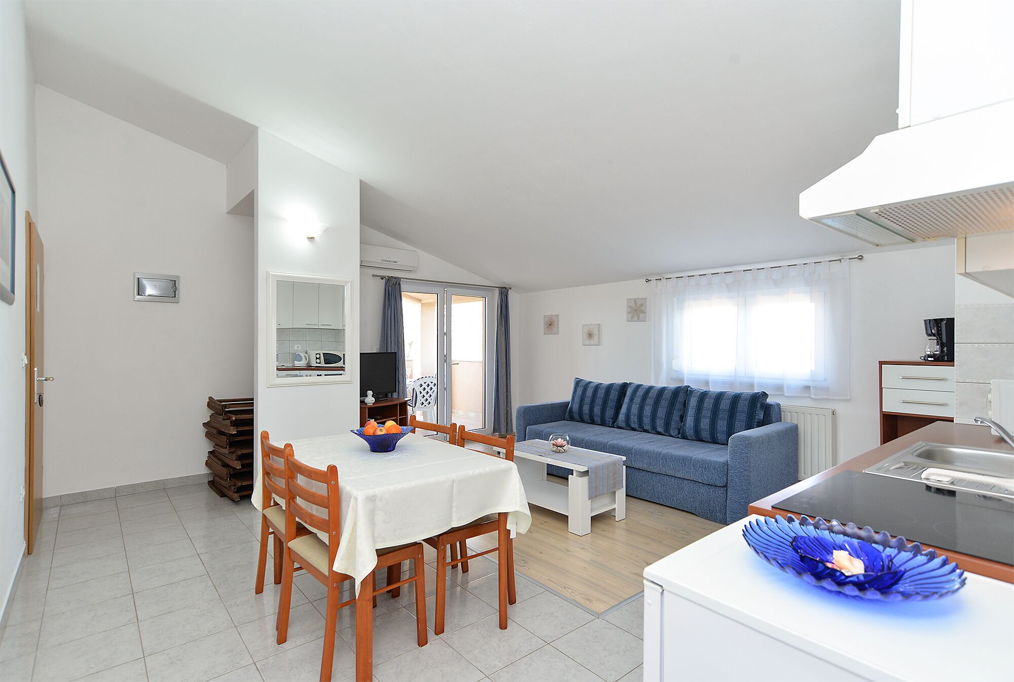 Un espace de vie compact comprenant un coin repas, une kitchenette et un canapé.