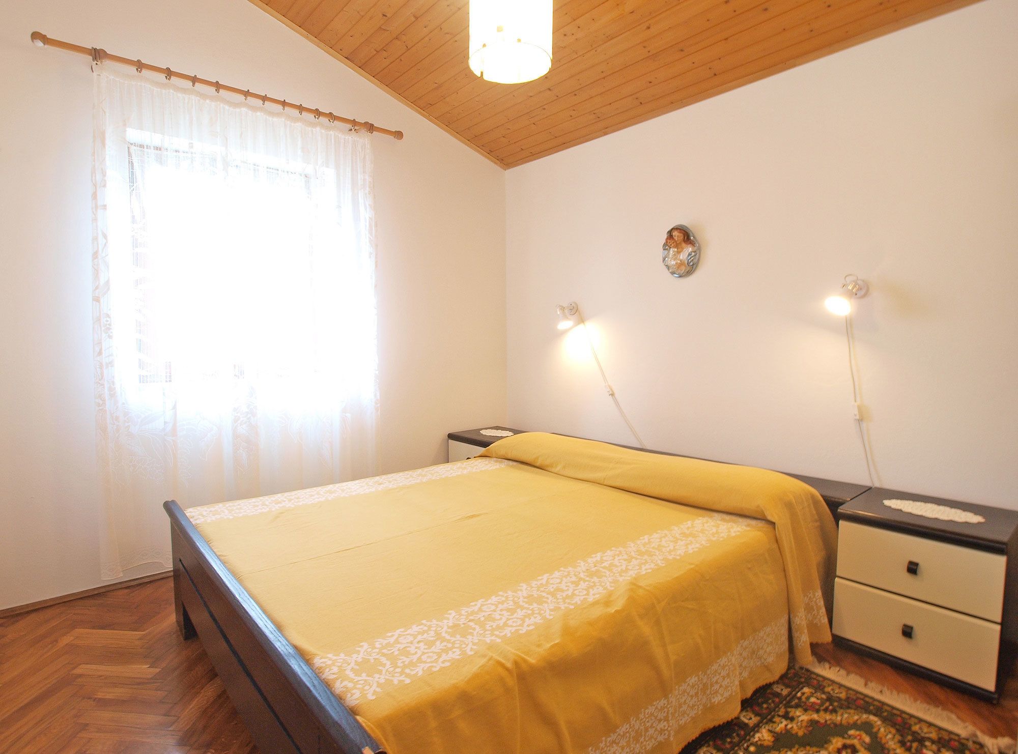 Une chambre à coucher avec un lit, une table de chevet et une commode.