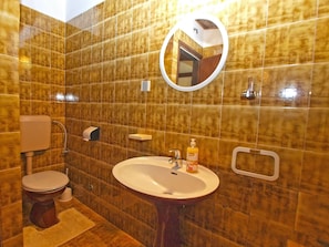 Ein Badezimmer mit Toilette, Waschbecken und Spiegel.