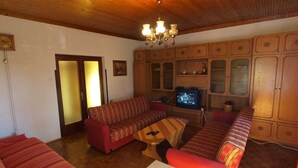 A cozy living room with a wooden ceiling, a sofa set, a television, and wooden cabinets. - Apartment 731 (Pula)