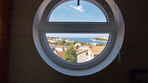 A round window with a clear view of a coastal town and the sea. - Apartment 761 (Medulin)