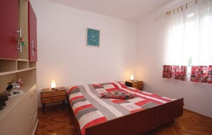 A bedroom with a bed, two bedside tables, a wardrobe, a window with curtains, and a wall-mounted picture. - Apartment 773 (Fazana)