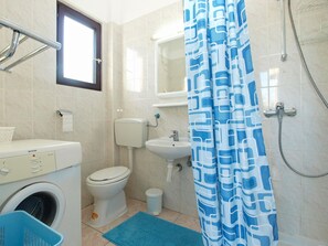 A bathroom with a toilet, sink, and shower. - Apartment 792 (Pula)