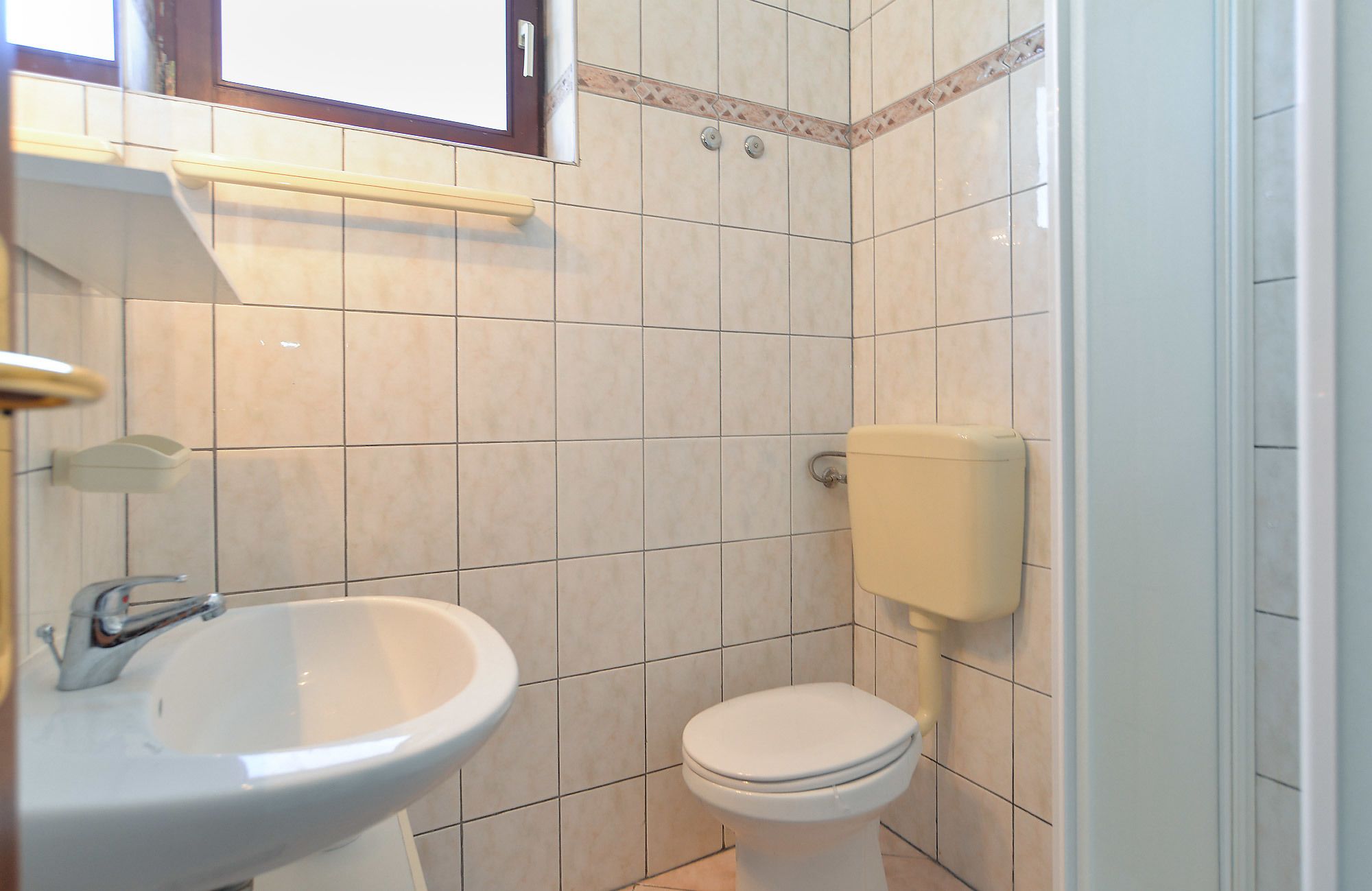 Een badkamer met een wastafel, toilet en douche.