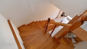 Un escalier en bois, doté d’une rampe, menant à l’étage supérieur.