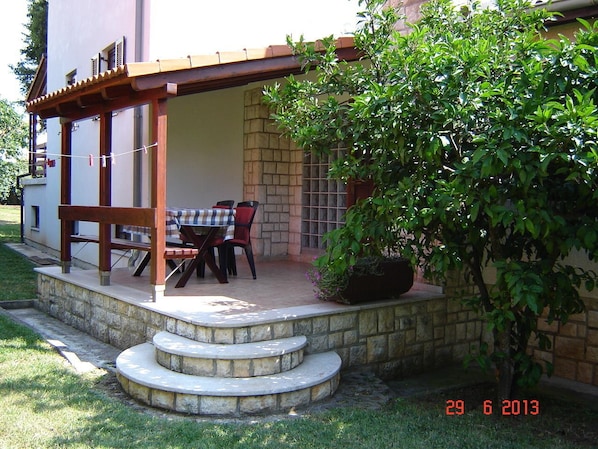 Relax in a serene outdoor space with a pergola, table, and comfortable seating.