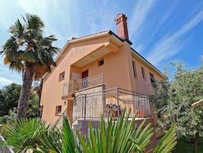 Enjoy the view from the upper-floor balcony with a potted plant and surrounding greenery.