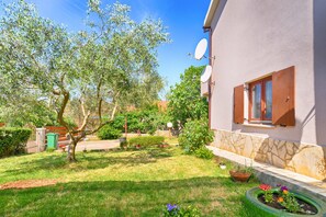 Enjoy a peaceful retreat in this serene garden setting, surrounded by lush plants and flowers.