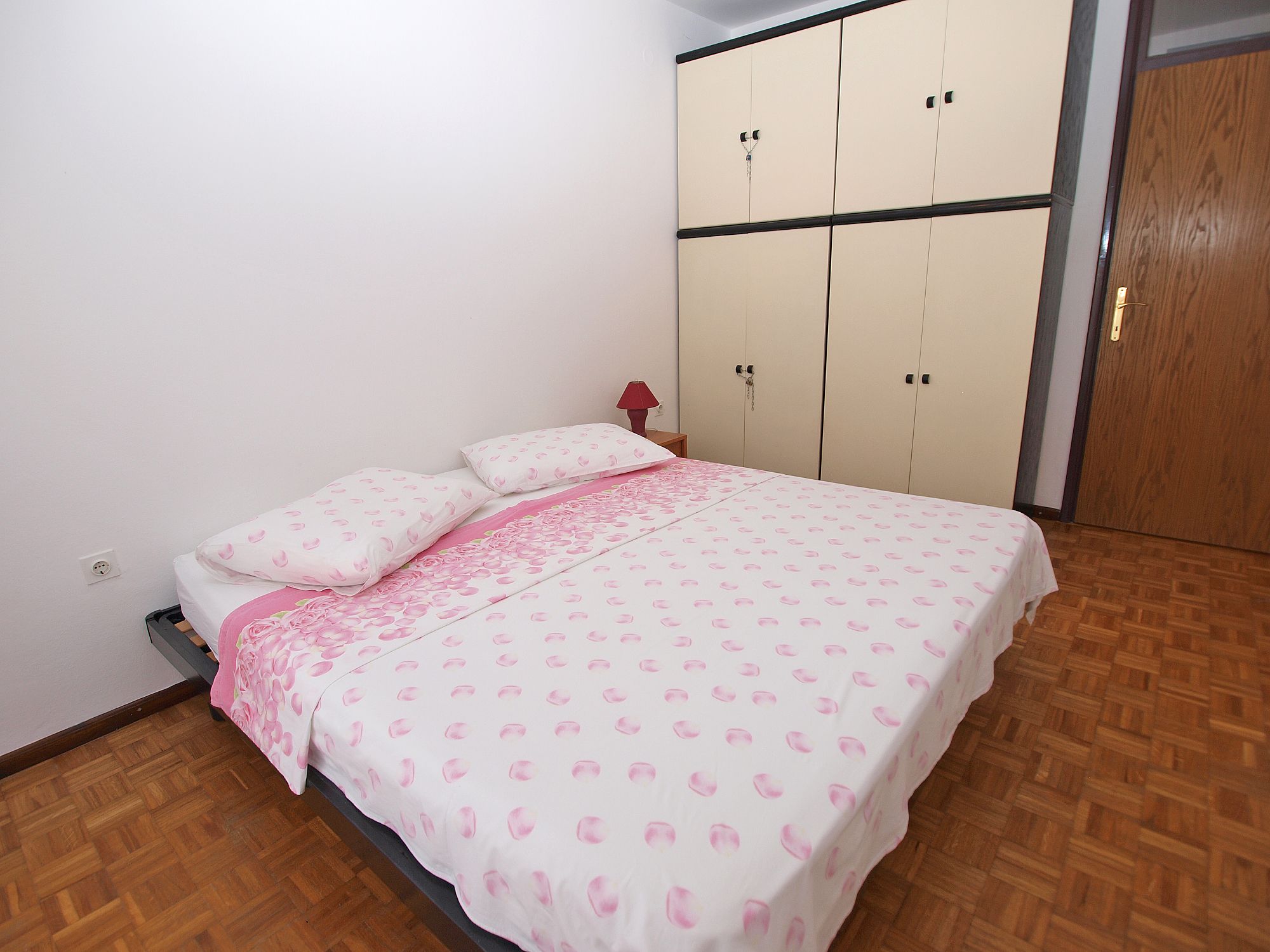 Un dormitorio con cama, armario y puerta.
