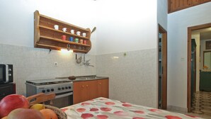 Eine Küche mit einem Holzboden über dem Herd, einer gefliesten Rückwand und einer Fruchtkorb auf der Arbeitsfläche.
