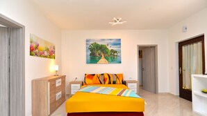 A bedroom with a bed, nightstands, a dresser, a painting, and a door. - Apartment 925 (Fazana)