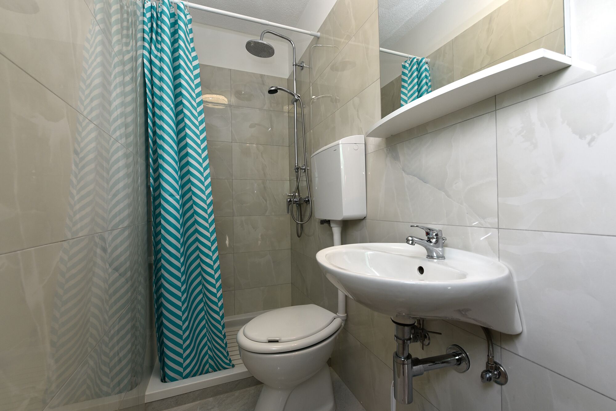 A bathroom with a shower, toilet, and sink.