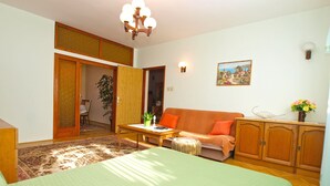 A room with a bed, a sofa, a table, and a cabinet. - Apartment 933 (Fazana)