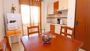 A compact kitchen with a dining table, chairs, and a coffee maker. - Apartment 946 (Pula)