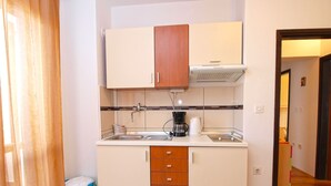 A compact kitchen with a sink, a coffee maker, and a cabinet. - Apartment 946 (Pula)