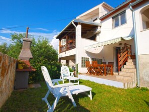 A two-story house with a balcony, outdoor furniture, and a stone structure. - Apartment 958 (Pula)