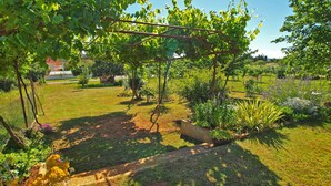 A garden with a pergola, various plants, and a lawn. - Apartment 979 (Medulin)