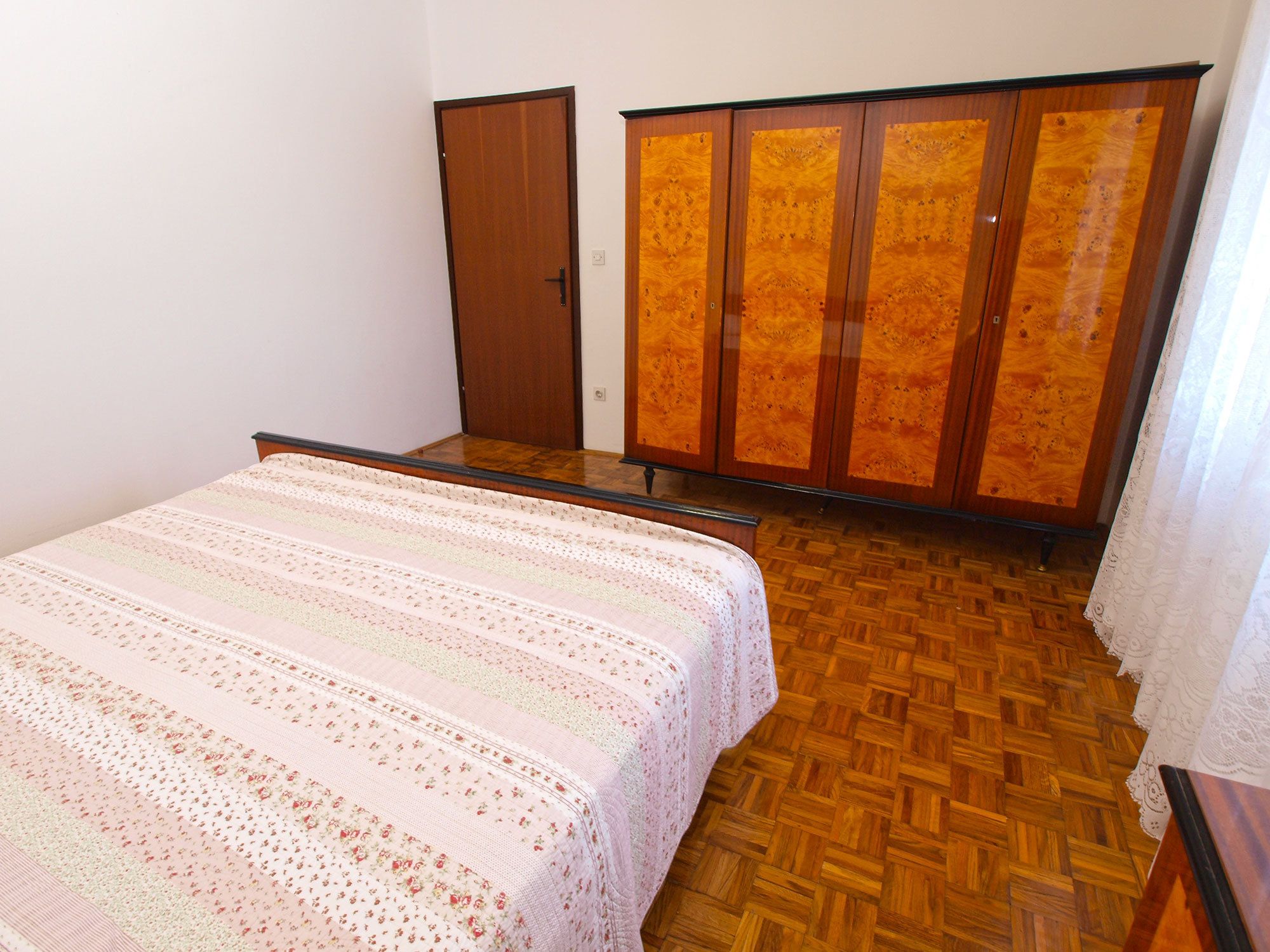 Un dormitorio con cama, armario y puerta.
