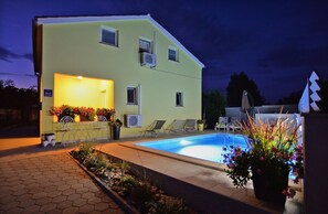 A two-story building with a swimming pool, outdoor seating, and potted plants. - House 1044 (Svetvincenat)