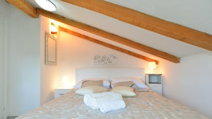 A bedroom with a bed, two bedside tables, a wall-mounted lamp, and a ceiling light. - House 1044 (Svetvincenat)