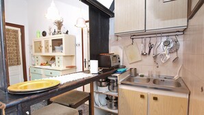 A compact kitchen with wooden cabinets, a built-in sink, and a toaster. - Apartment 1050 (Rovinj)