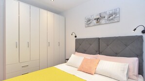 Ein Schlafzimmer mit Bett, Kleiderschrank und einem Wandbild.